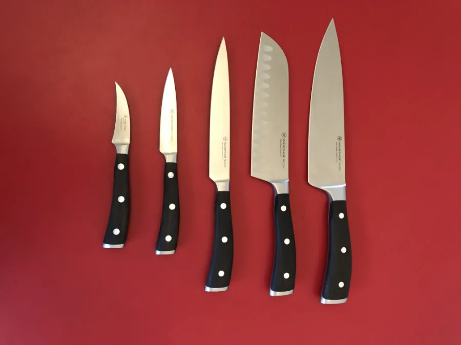 set of sharpened kitchen knives on a red background